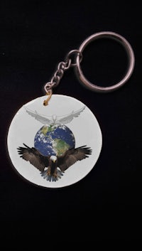 a key chain with an eagle and earth on it