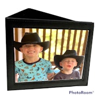 two boys wearing cowboy hats in a black frame